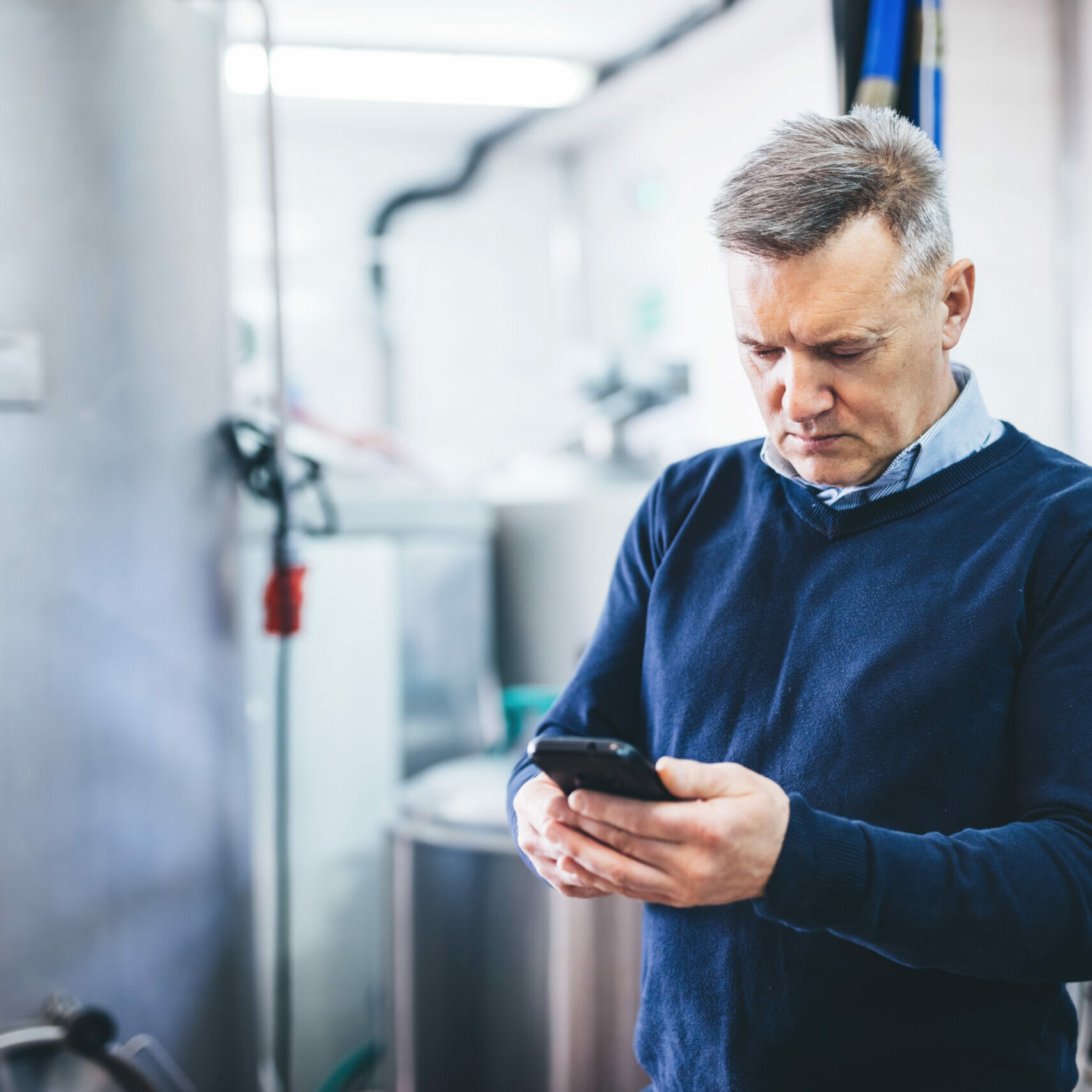 Craft brewery owner or manager talking on mobile phone doing business